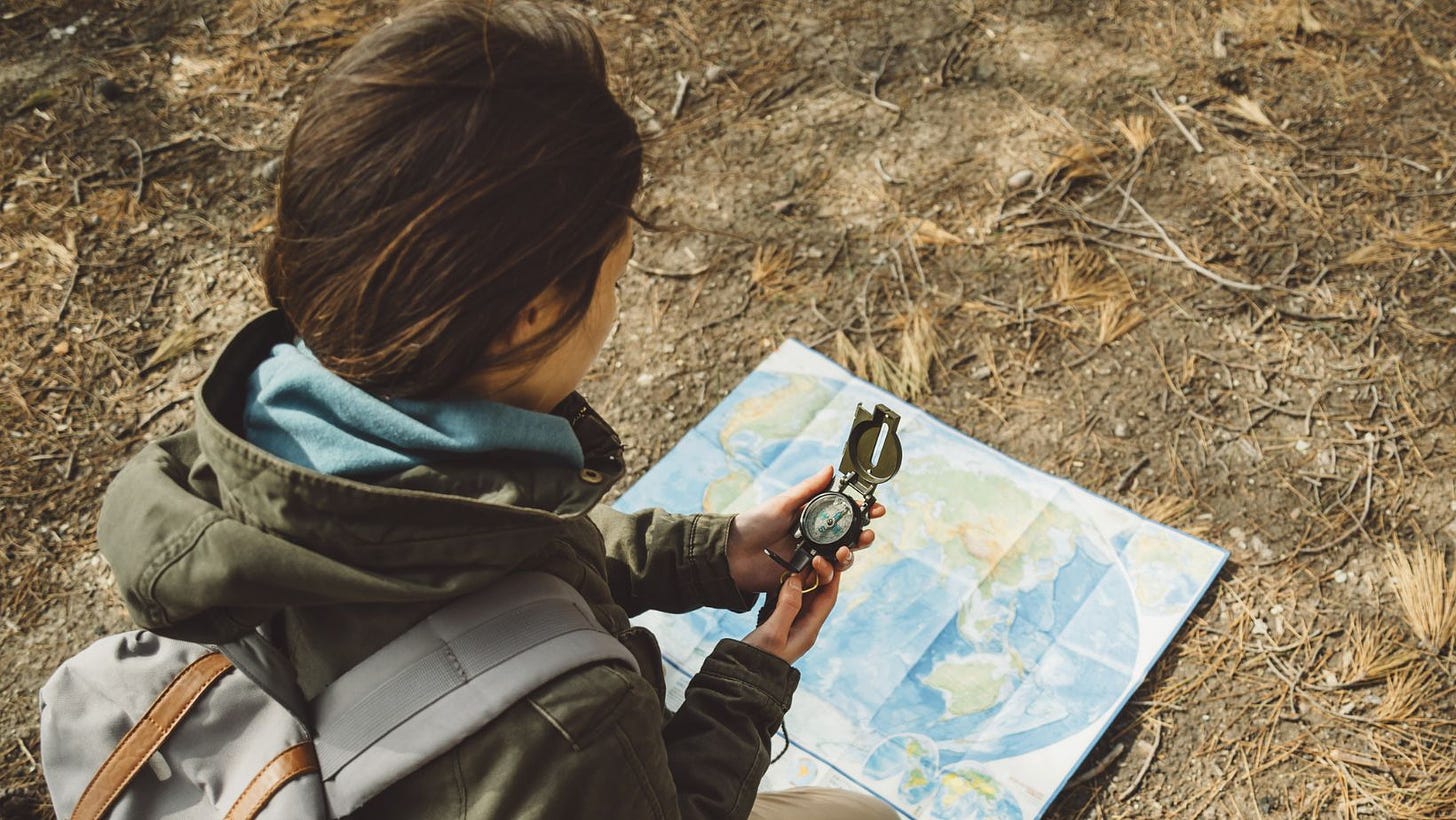 woman looking at map with compass