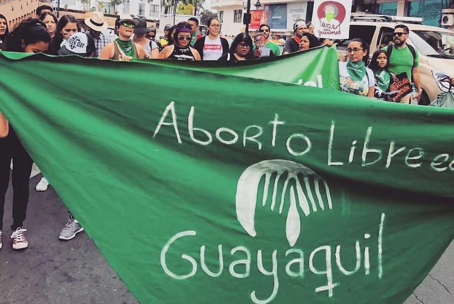 Mexican activists wearing green, the official color of the abortion access movement in latin america, carrying a sign saying aborto libre