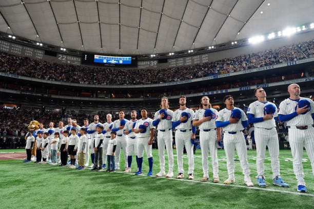 Chicago Cubs players are seen on field during the national anthem before the game between the Chicago Cubs and the Hanshin Tigers at Tokyo Dome on...