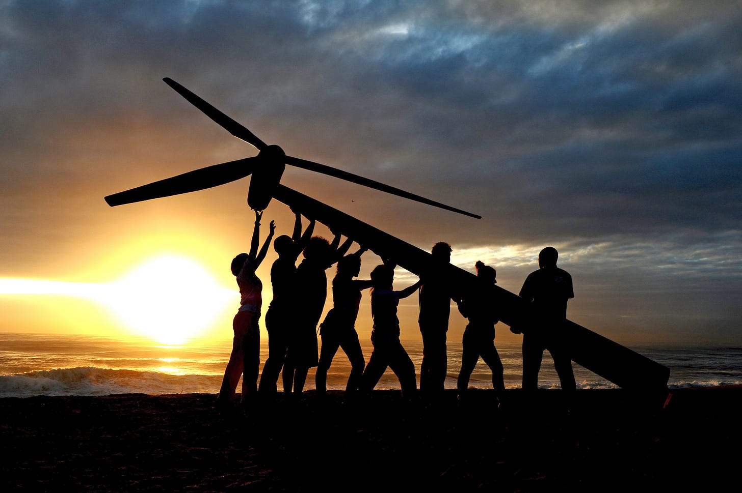 Climate activists raise a wind turbine on the beach at dawn in Durban, South Africa.