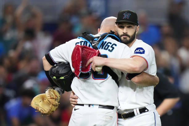 Jacob Stallings of the Miami Marlins embraces Tanner Scott after a game against the Milwaukee Brewers at loanDepot park on September 24, 2023 in...