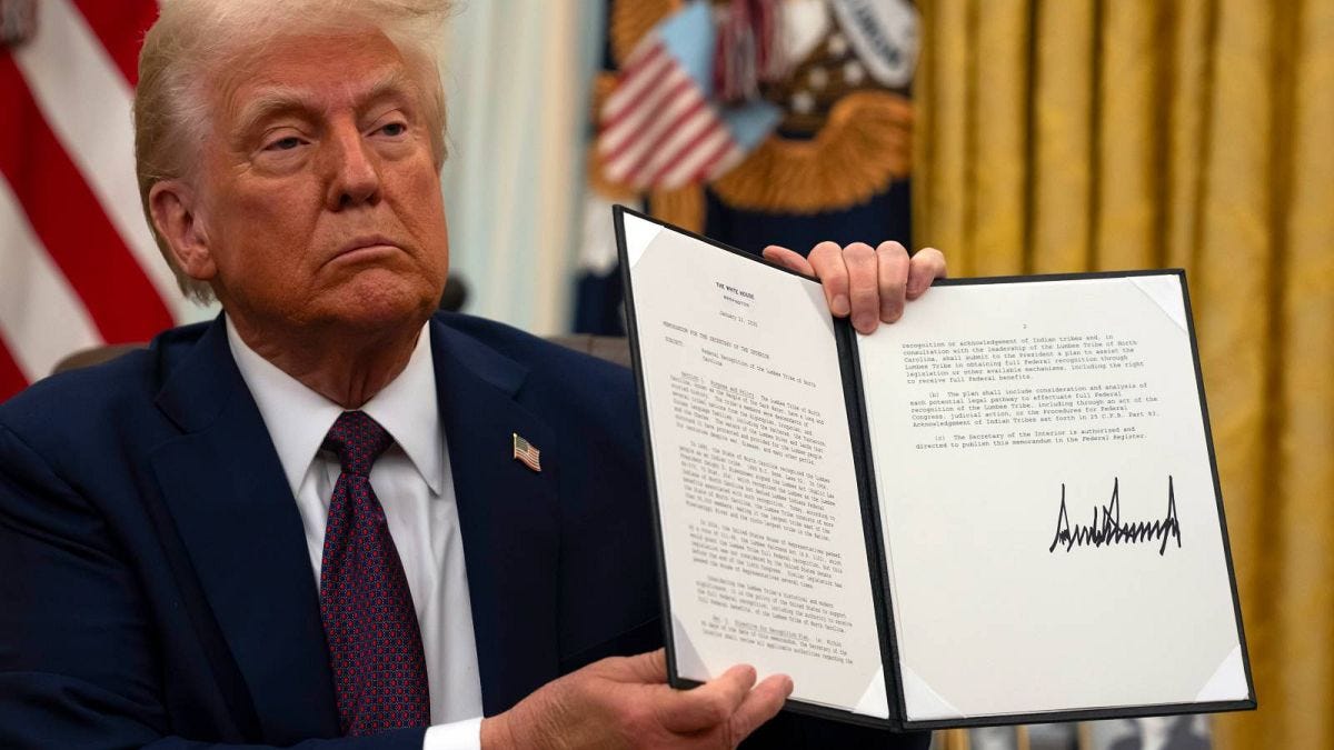 President Donald Trump holding up a order for clemency for anti-abortion protesters as he signs executive orders in the Oval Office of the White House, Thursday, Jan. 23, 2025