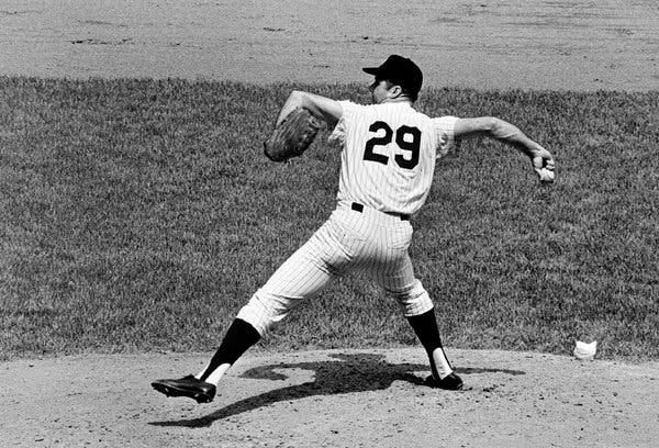 A black-and-white photograph of Colavito wearing a Yankees uniform and throwing a pitch from the pitcher’s mound.