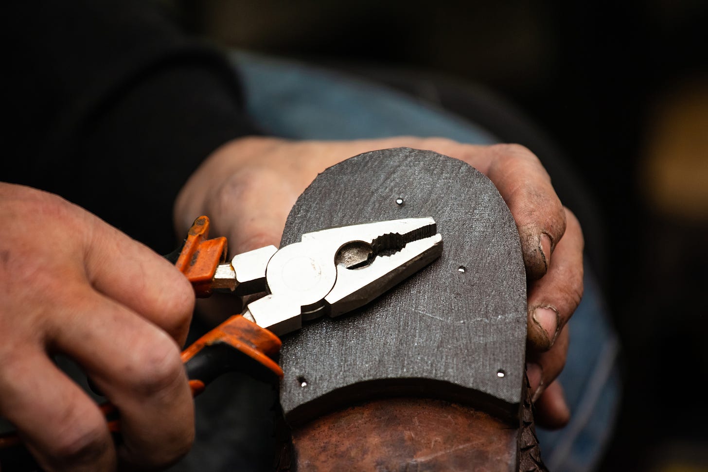 A cobbler repairs a shoe.