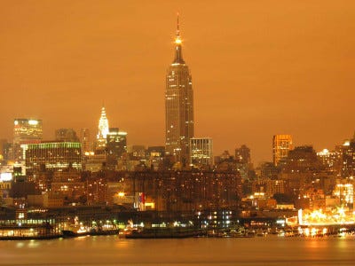 an orange sky over a city showing how the night sky is affected by light pollution