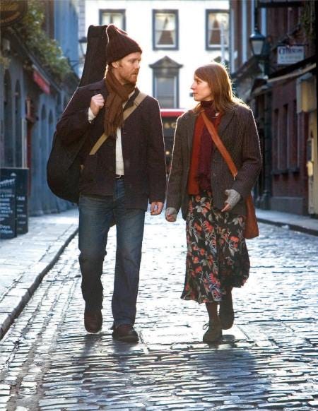 Screenshot from the movie "Once" showing the two main characters walking down the street together