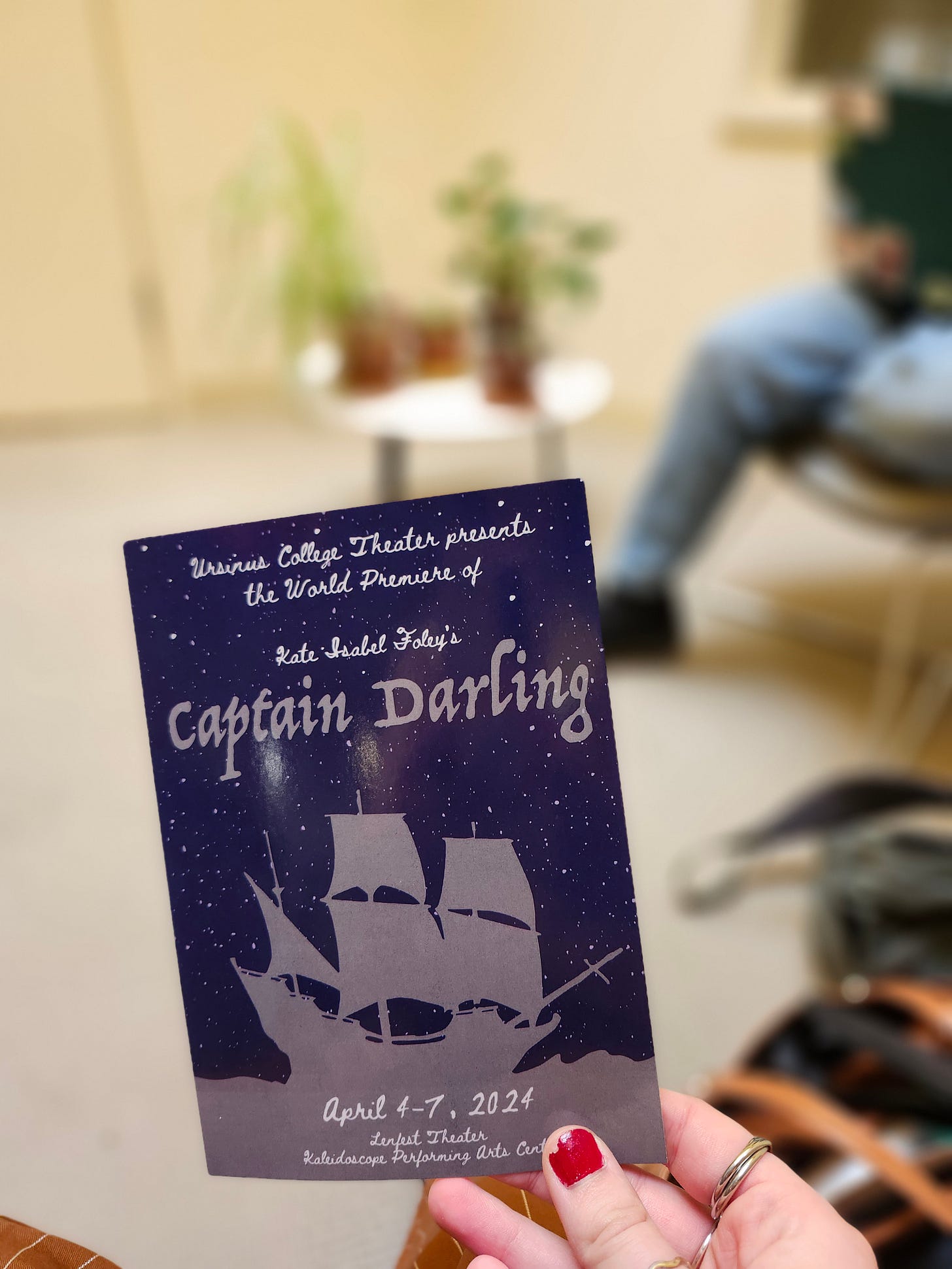 Kate holding a promotional postcard for Captain Darling