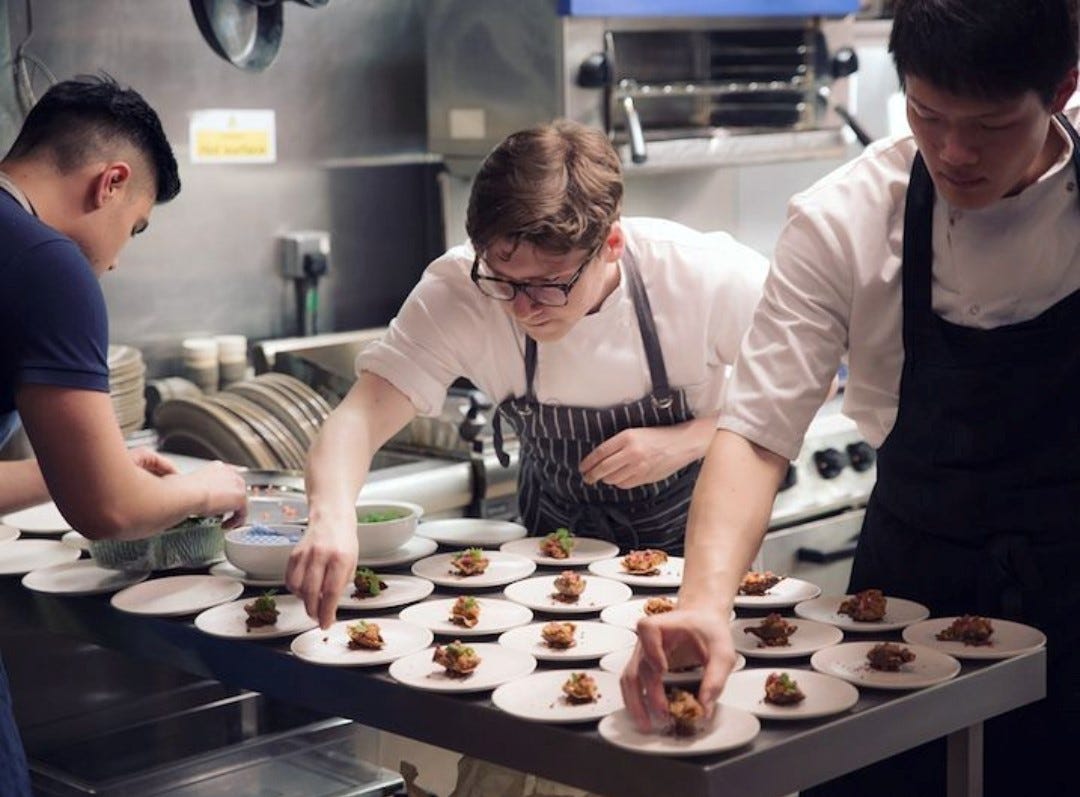 group of chefs plating food