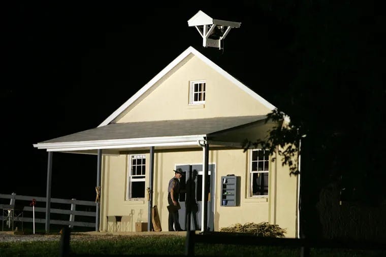 A state trooper closes the front doors of Nickel Mines School, where a gunman killed several people and injured others in Nickel Mines, Pa., on Oct. 2, 2006. Eighteen years later, shooting survivor Rosanna King has died.