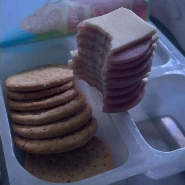 all the meat and cheese from a Lunchable stacked up and with a big bite taken out of it