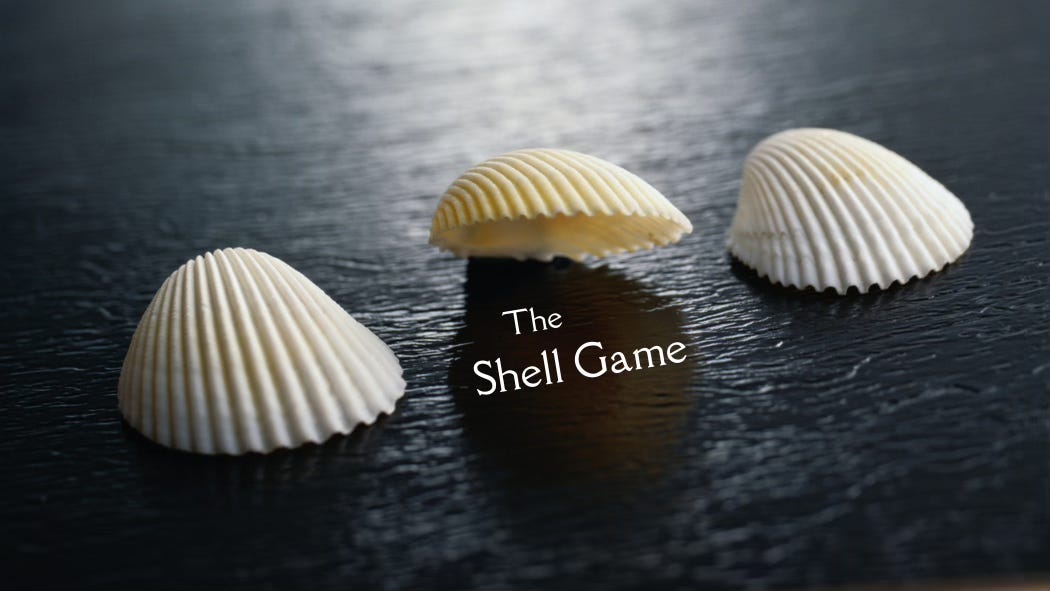 The Shell Game: Three seashells lay on a dark table. The center one has been lifted to reveal what's underneath it: nothing.