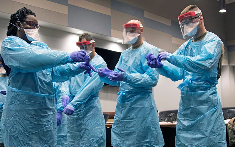 A group of healthcare workers donning PPE.