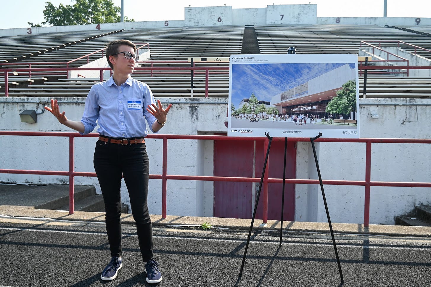 Morgan speaks in front of the East Grandstand next to an easel with a rendering of what the renovated space would look like