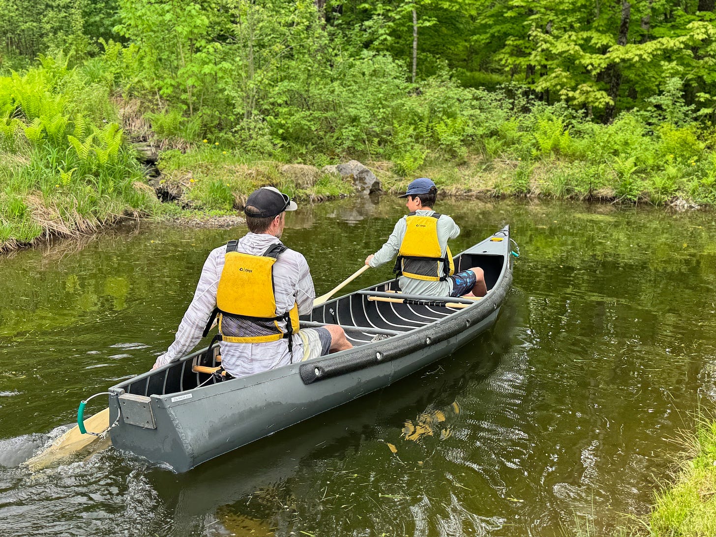 Paddling the Radisson canoe on a small body of water.