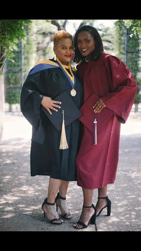 Two women dressed in graduation gowns