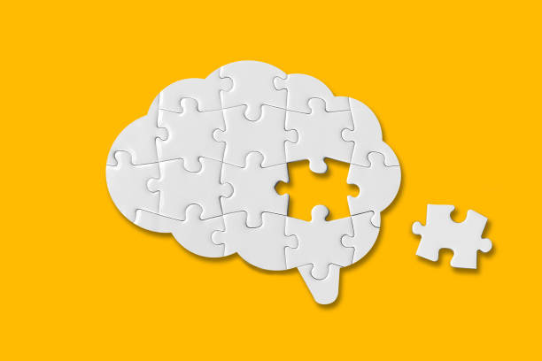 brain shaped white jigsaw puzzle on yellow background - dementia bildbanksfoton och bilder