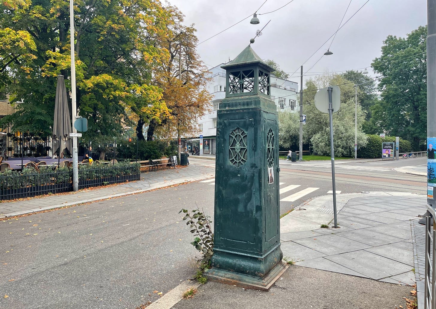 this photo and next; a green metal structure, about the size of a phone booth but more narrow and closed.