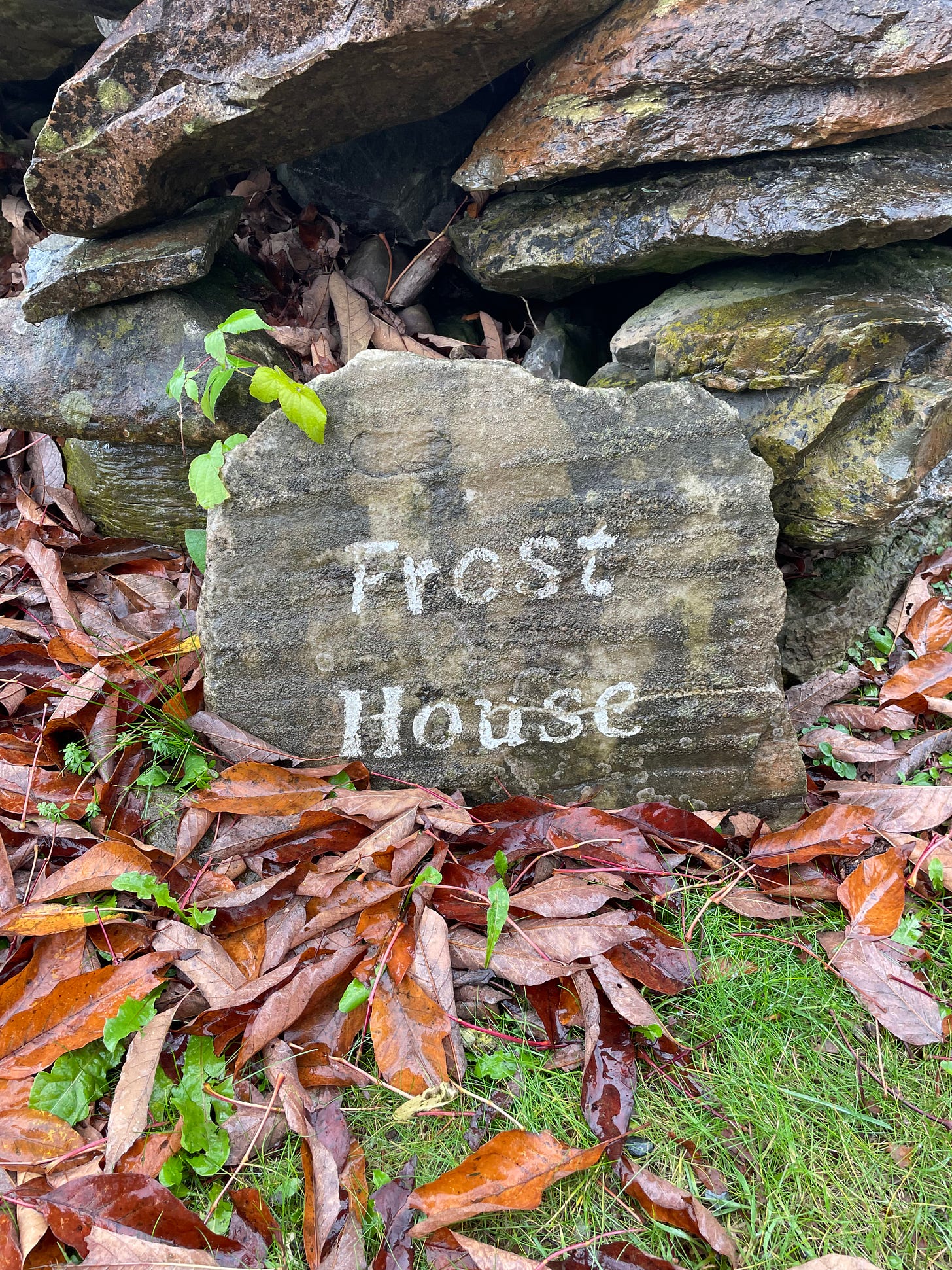 A stone on the ground with the words Frost House on it