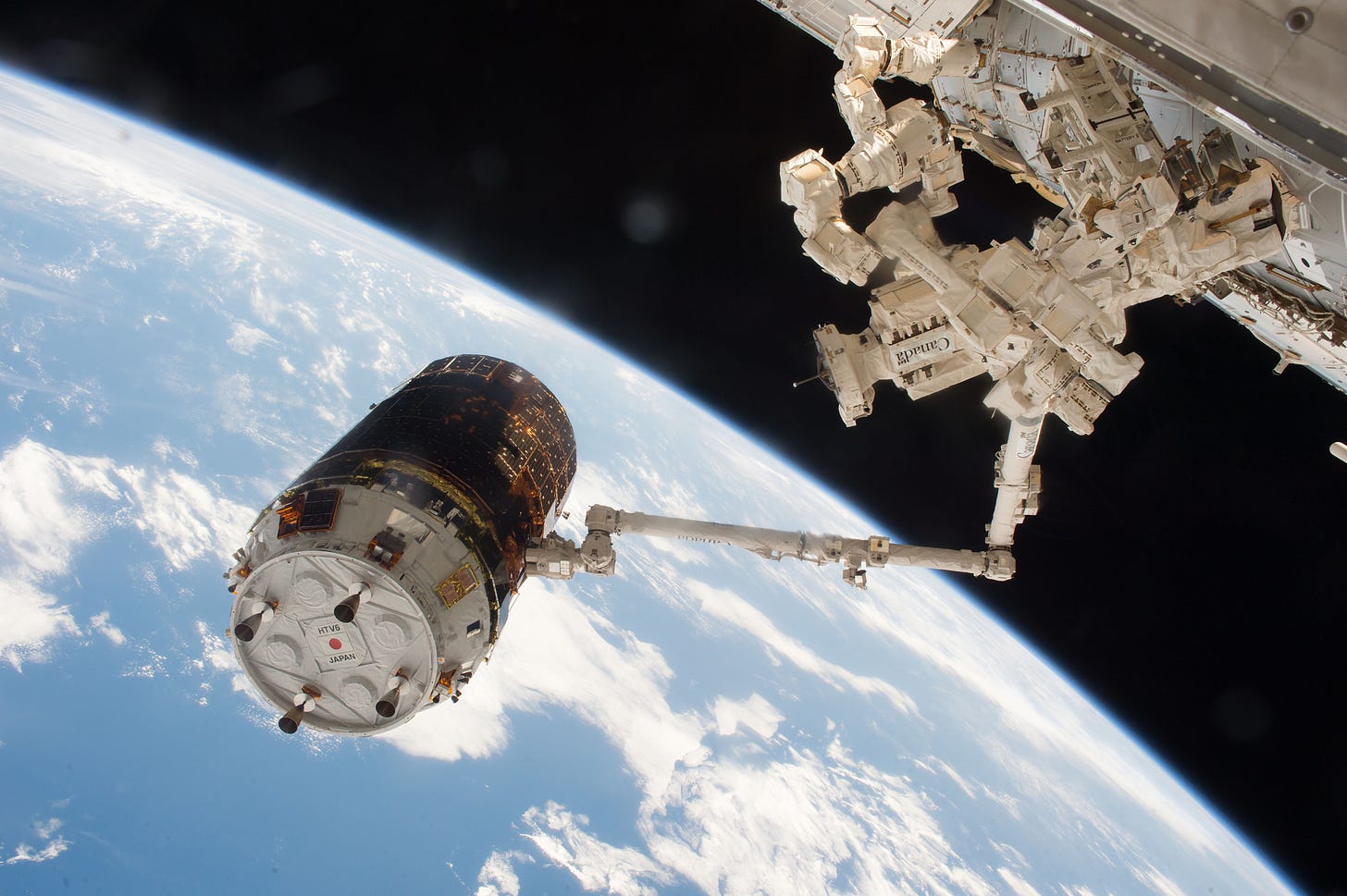 Japanese H-II Transport Vehicle-6 (HTV-6) cargo vehicle is seen grappled by the International Space Station robotic arm