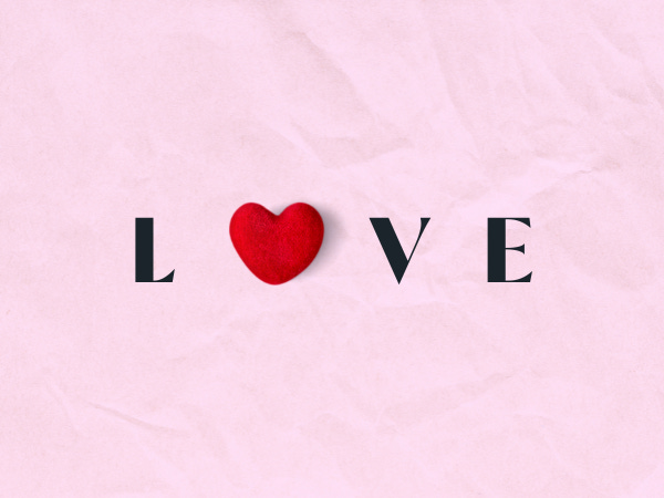 The word love in black text against a pink background with the O replaced by a red heart