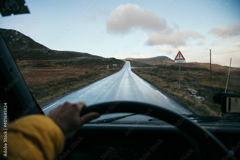 POV shot with focus on the road of woman drive camping van or normal car.  Hold