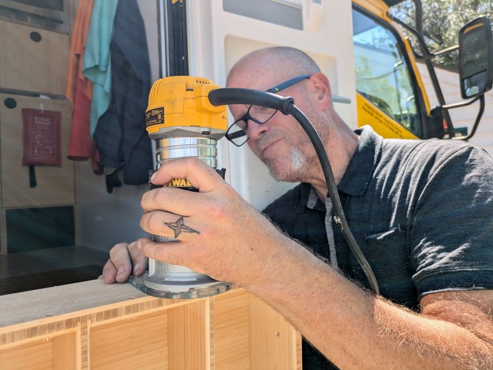 Andy working with power tools on a bamboo shelf-case outdoors