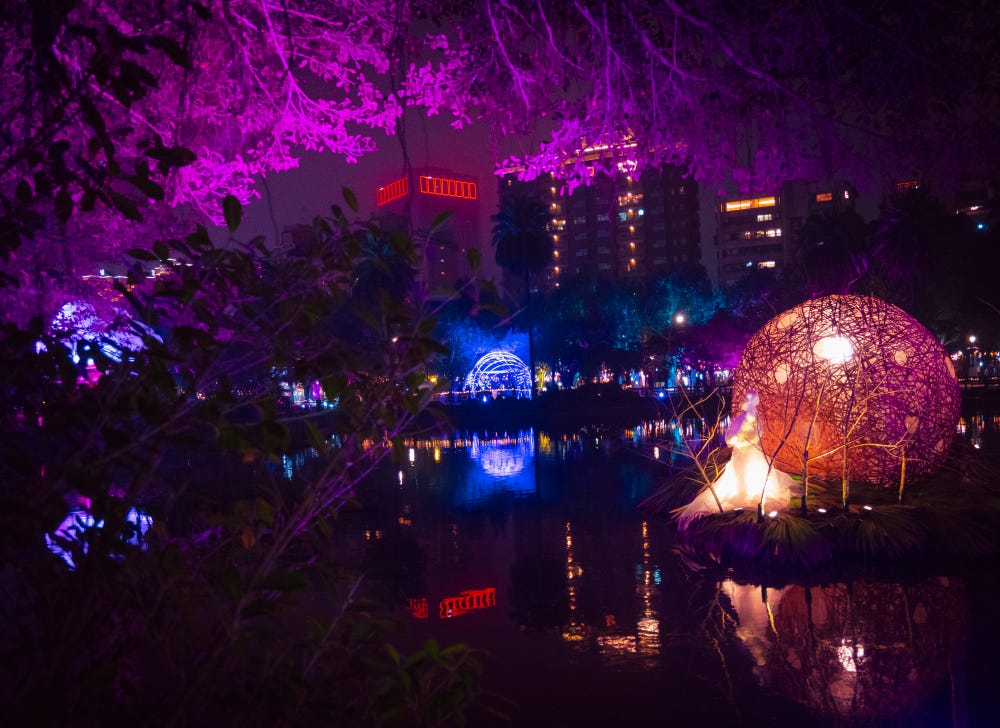 A glowing orb lantern is reflected in the Sun Yat Sen Memorial Hall pond at the 2023 Taiwan Lantern Festival
