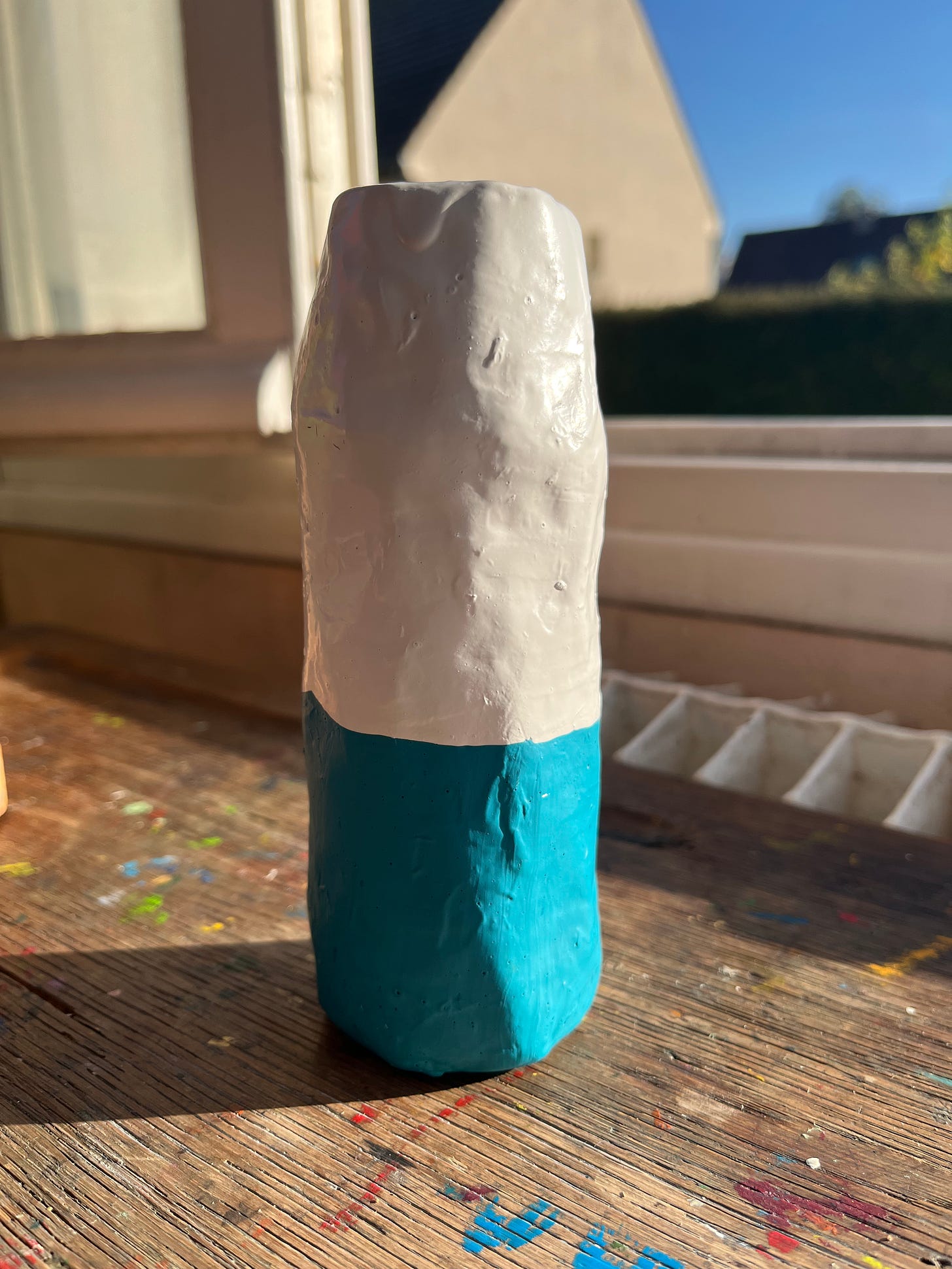 A paper mache bottle in white and blue