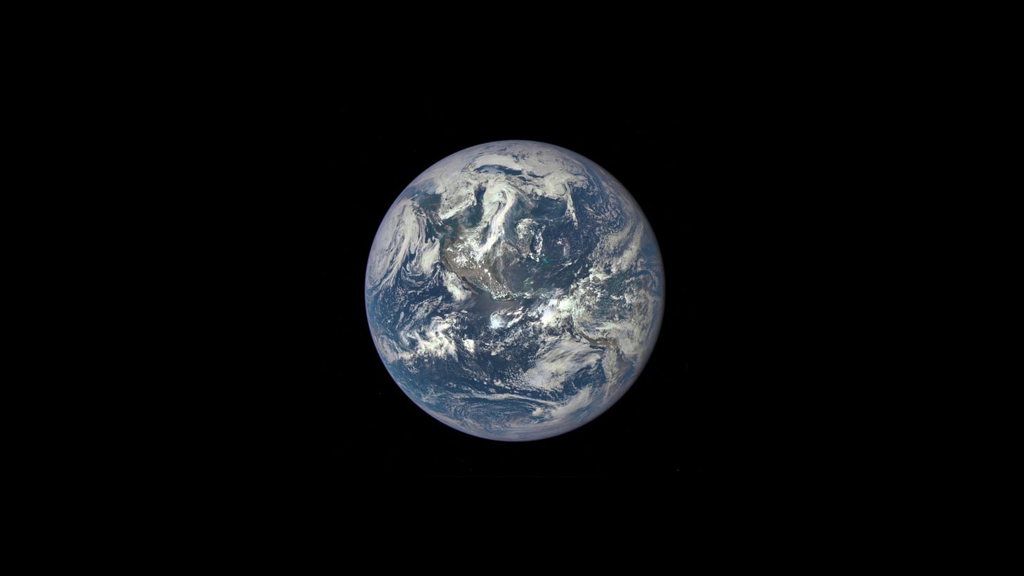 a photograph taken through their window of the earth (the big blue marbel) from the Apollo 17 spaceship against a black background