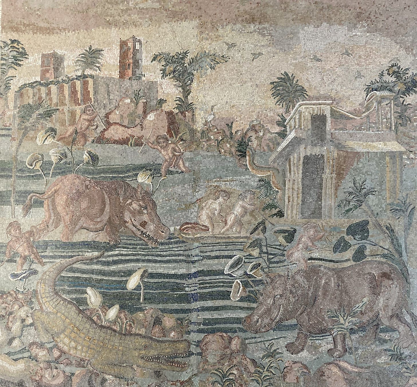 Ancient Roman mosaic showing hippos, a crocodile, various men who might be hunting them, date palms, lotus plants and buildings. Stylised but still extremely detailed