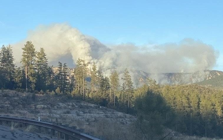 Smoke rising in the distance along a mountain ridge.