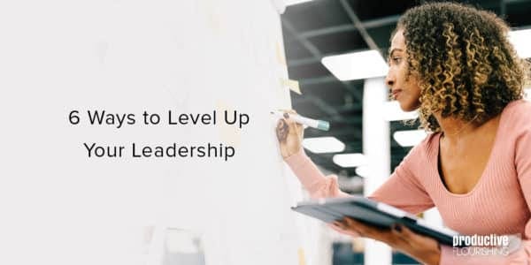 Black woman in a pink top writing on a whiteboard. Text overlay: 6 Ways to Level Up Your Leadership