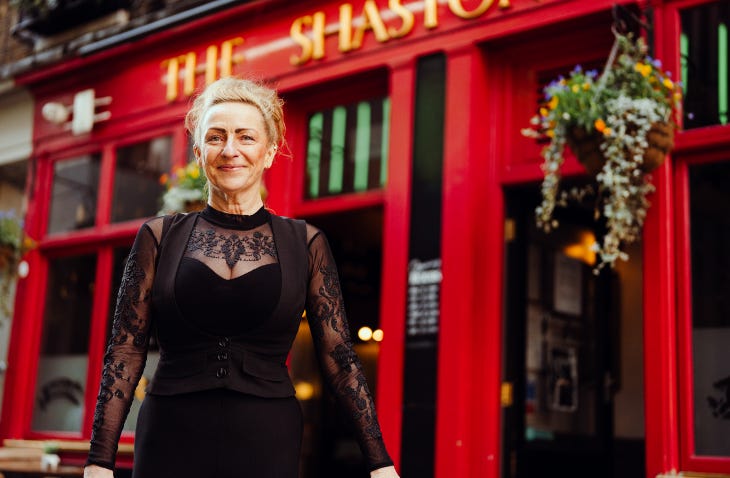 Landlady standing outside her pub