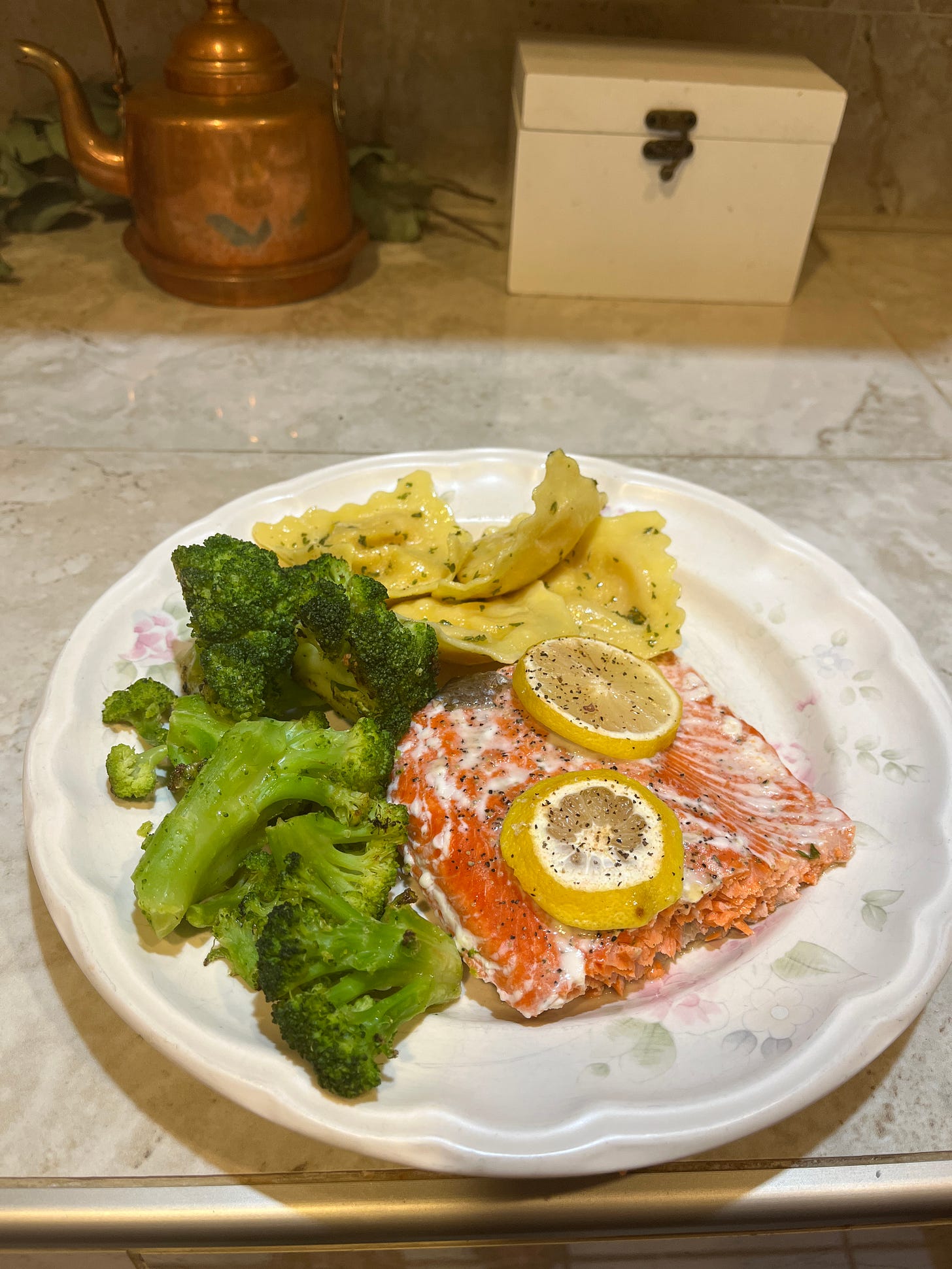 Healthy plate of salmon with lemon slices, broccoli, and ravioli