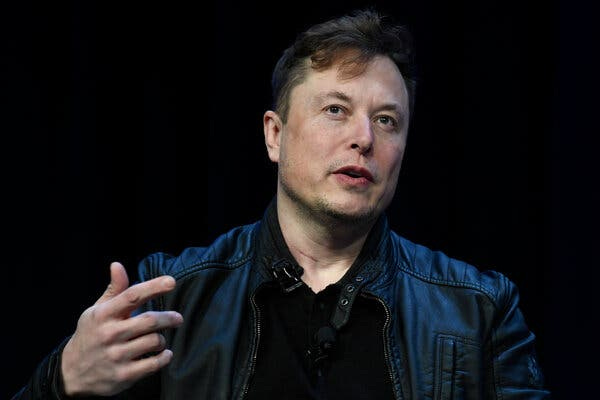 Elon Musk wearing a black leather jacket and black shirt.