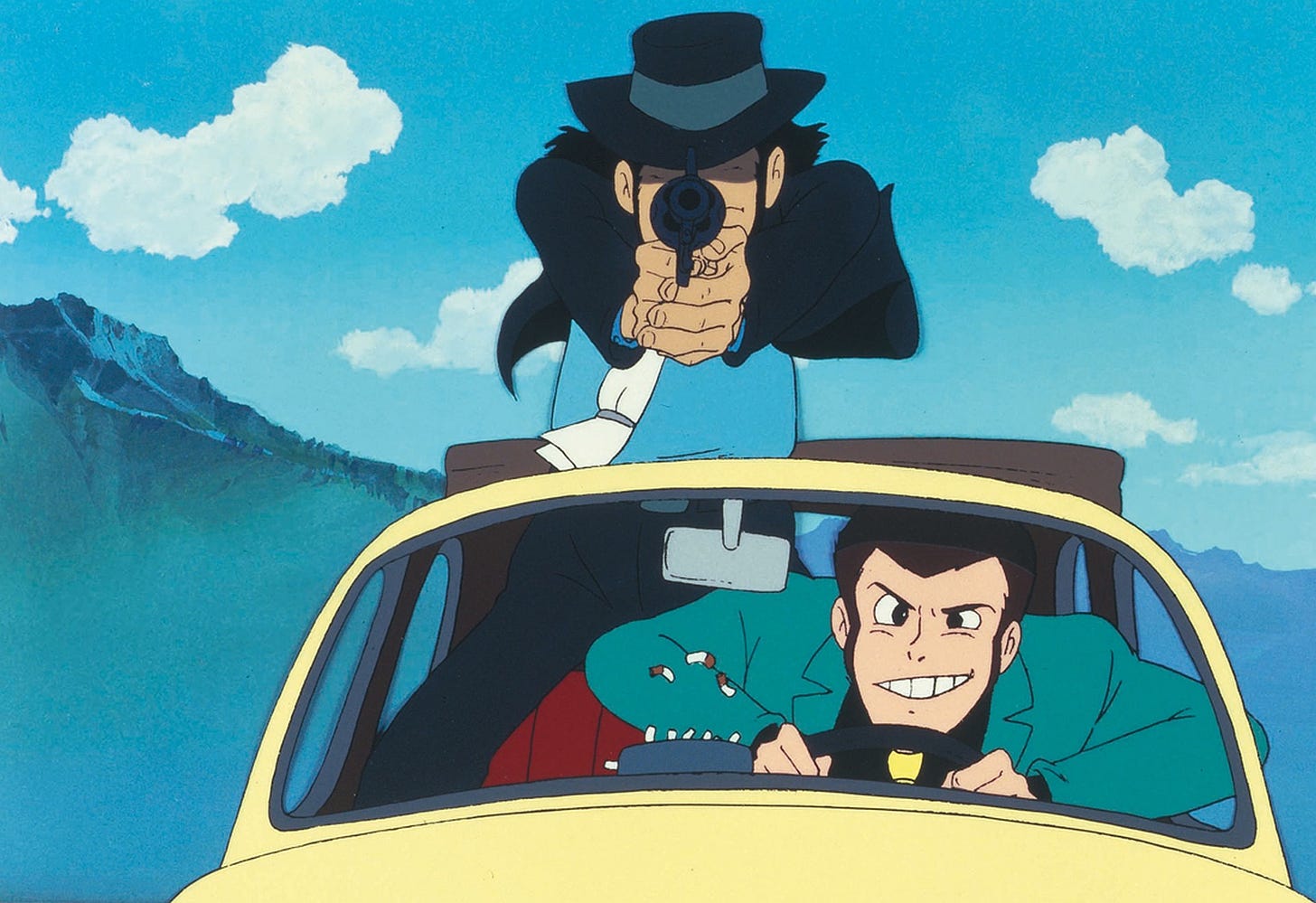 Lupin e Jigen a bordo della 500 gialla. Lupin è alla guida, mentre Jigen è in piedi, parzialmente fuori dal tettuccio, e punta una pistola davanti a sè. Sullo sfondo le montagne e il cielo limpido con qualche nuvola bianca