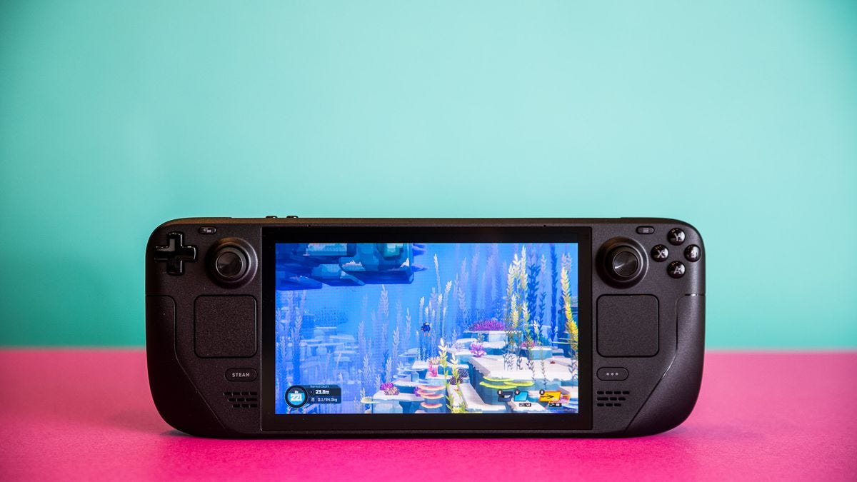 Photographs of the Steam Deck OLED, and of its hard zip-up case. Each photo is taken with the handheld sitting on a hot pink sheet of thick paper.