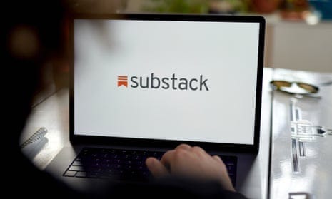 A laptop, with the screen displaying the Substack logo, sitting on a table.