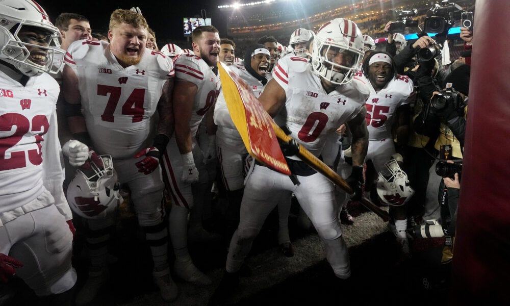 Wisconsin Badgers Football running back Braelon Allen chops down the Gophers goal posts