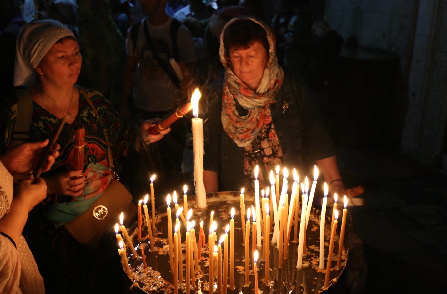 A group of people lighting candles

Description automatically generated