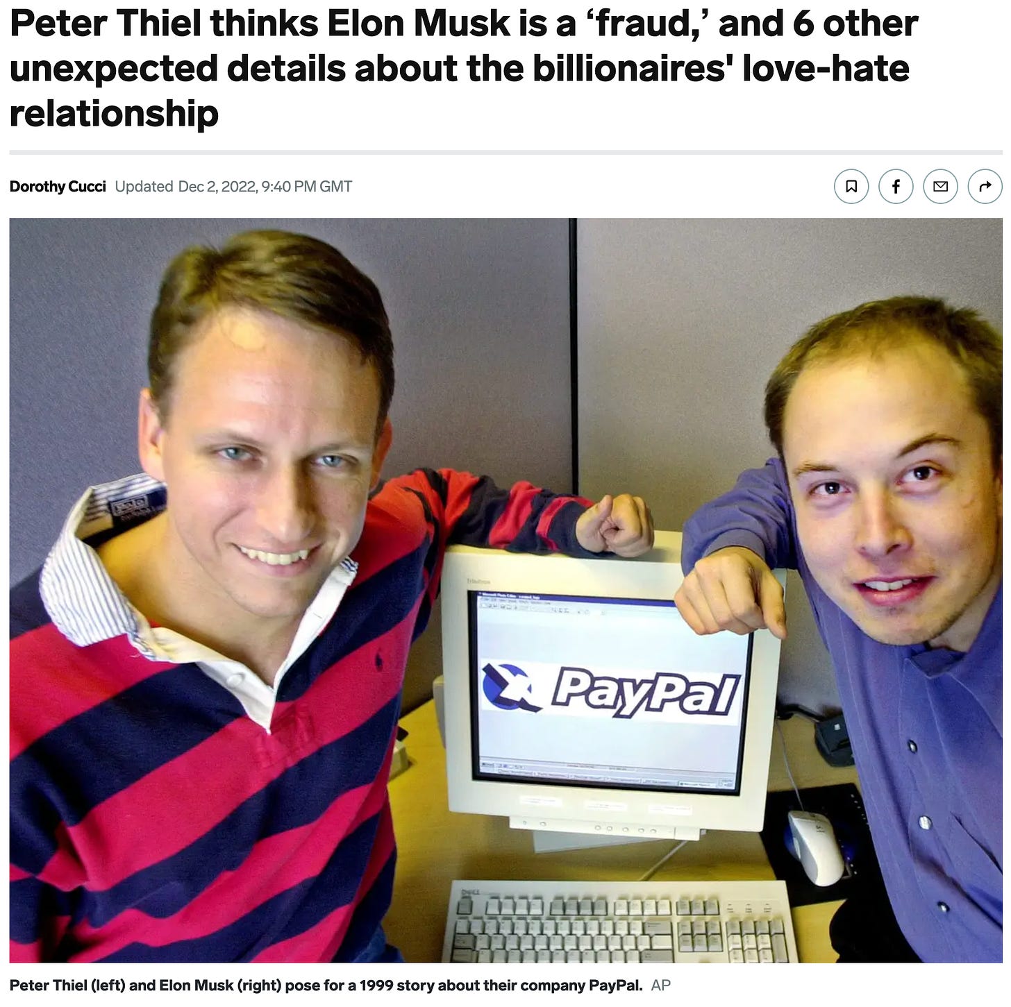 two men sitting next to an old PC