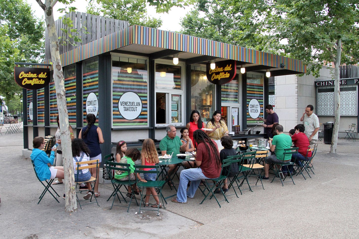 Diners sit at outdoor tables around the small "Cocina del Conflicto," in its incarnation serving Venezuelan cuisine.