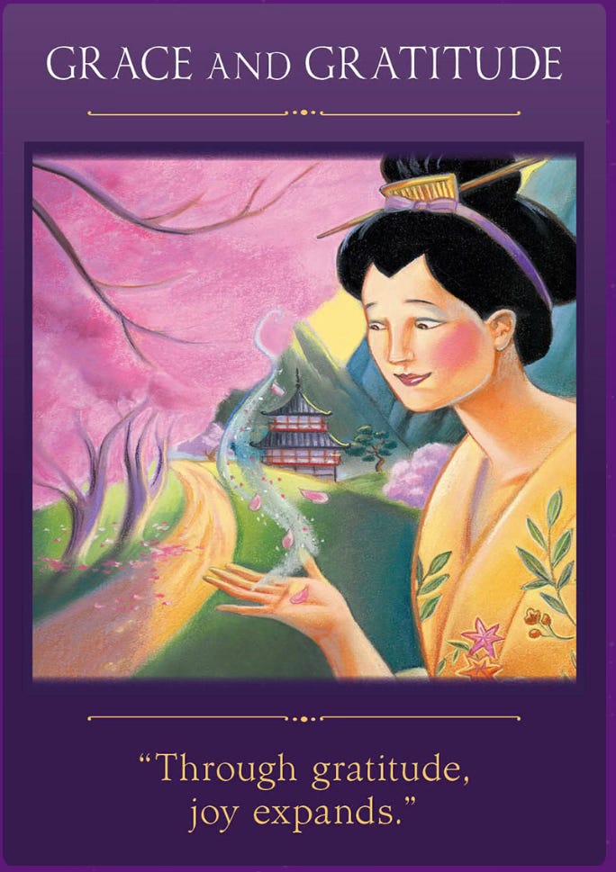 Grace and gratitude oracle card from The Sacred Traveler oracle card deck. A drawing of a Japanese woman wearing traditional clothes and hairstyle looking down at her open palm with wisps of smoke and cherry blossom petals.  in the background there's a pink cherry blossom tree in full bloom and a pagoda in the distance in front of mountains.