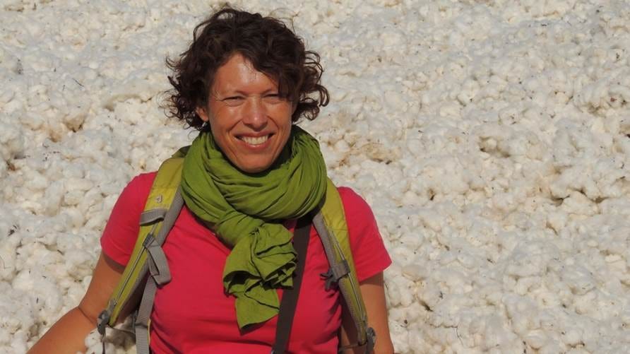 A person wearing a green scarf and a backpack

Description automatically generated