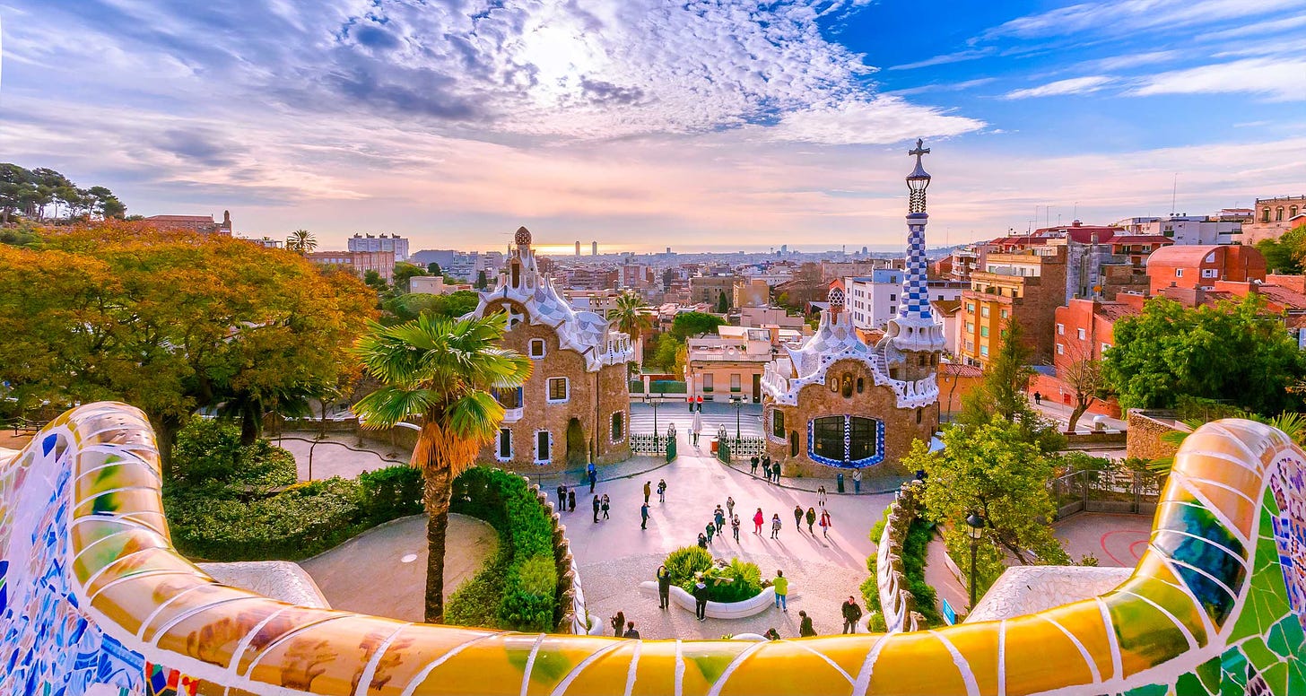 Colorful park with structures built by Gaudi overlooking the city of Barcelona.