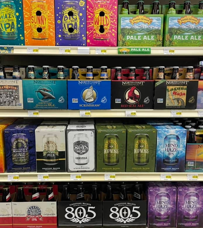 A grocery store end display of beer sixpacks and 12-packs (mostly beer from Firestone Walker Brewing)