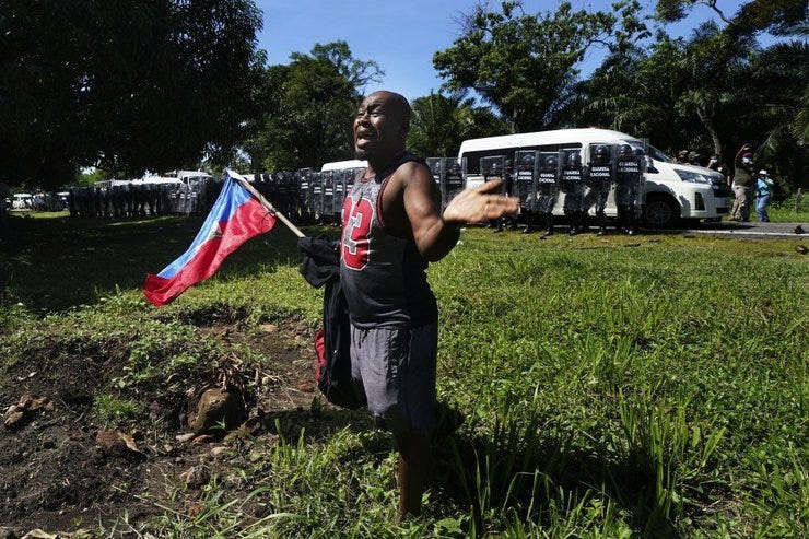 Un migrante haitiano sostiene la bandera de su país mientras suplica a la Guardia Nacional de México que no detenga a los migrantes que se dirigen a la frontera entre Estados Unidos y México. MARCO UGARTE AP