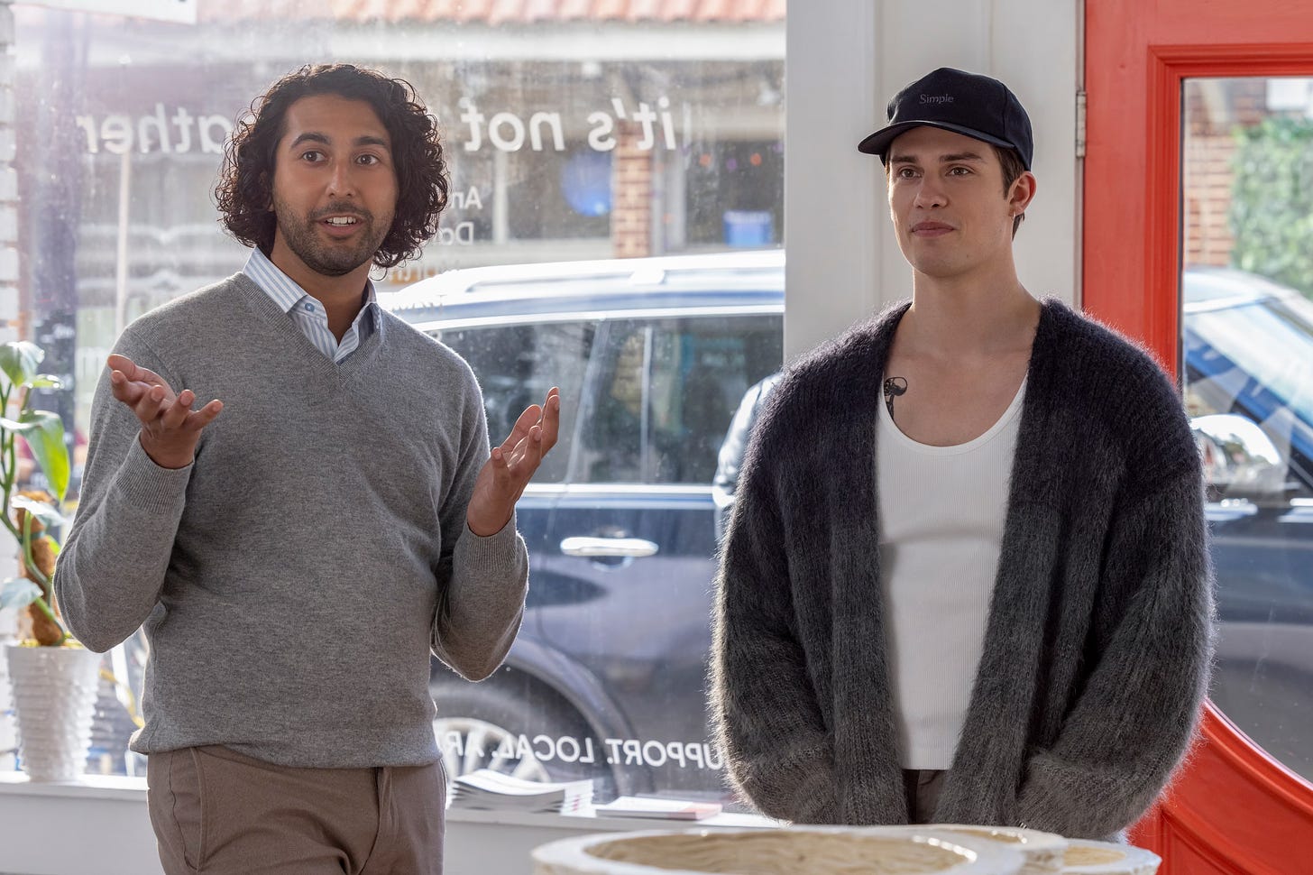 Cheech Manohar as Jeremy (left) and Nicholas Galitzine as Hayes (right) in THE IDEA OF YOU. Hayes is wearing a gray cardigan made with mohair.