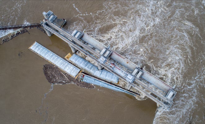 Three barges against the dam just south of downtown Louisville on Tuesday, March 28, 2023. One had been removed as of Friday.