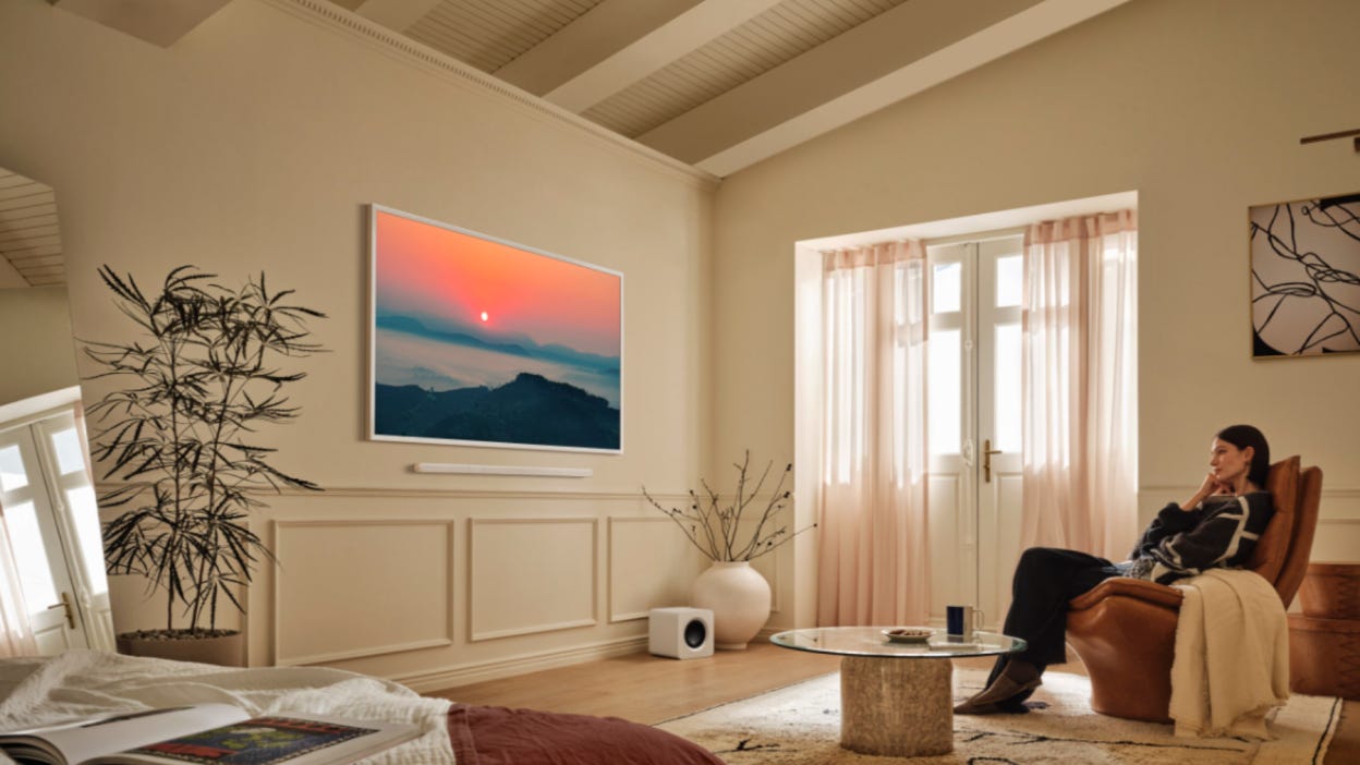 Person sitting in living room looking at Samsung's The Frame TV on wall